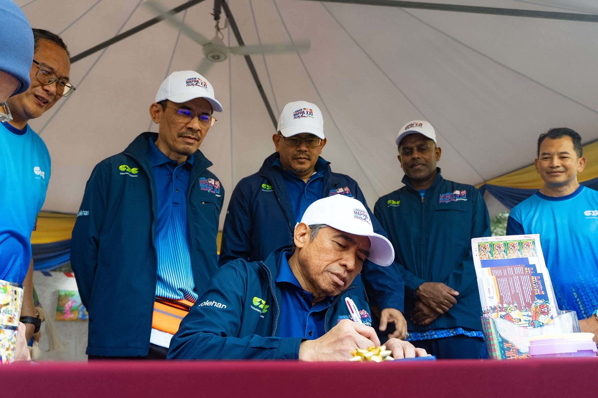 A participant signs an INKlusif postcard at the CDC booth.